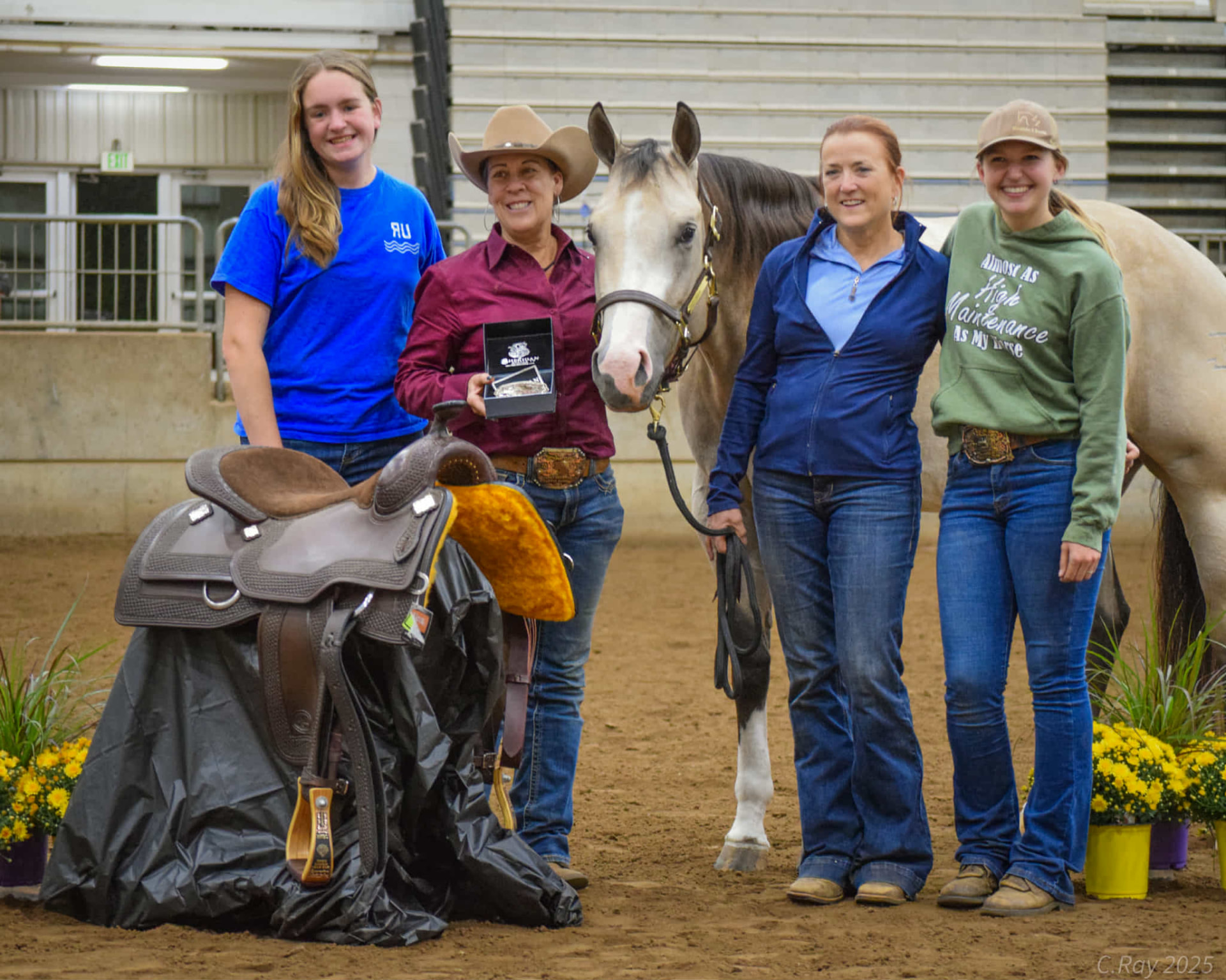Peggy Bond-Heath and her clients celebrating a championship with the award saddle